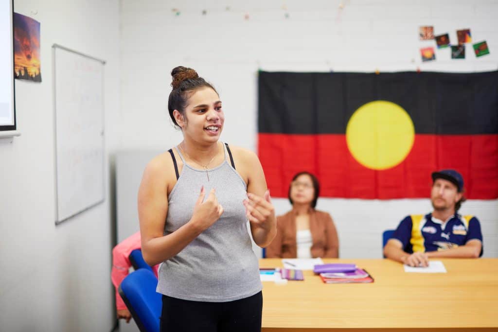 Young Aboriginal woman participating in the Skills for Education and Employment (SEE) program presents to her class about Indigenous culture in Australia.